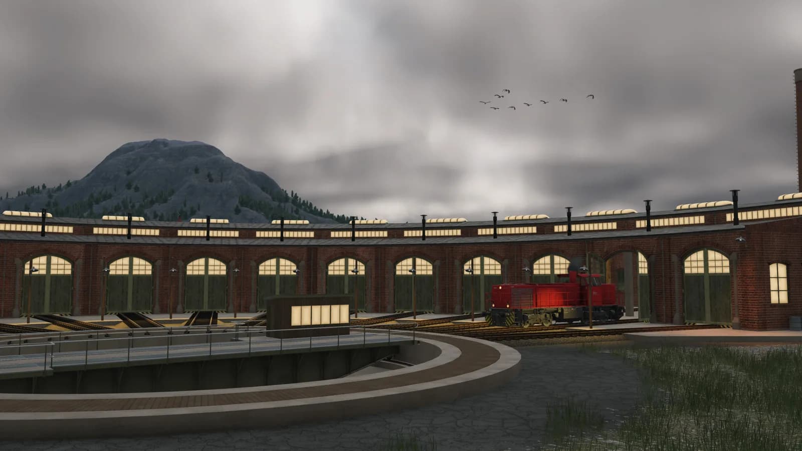Railway roundhouse beneath mountain skies